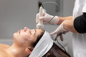 A woman receiving a Hydrafacial treatment at a skin clinic — a popular skincare procedure known for deep cleansing, exfoliation, and hydration. Learn about Hydrafacial cost in Hyderabad and its benefits for glowing skin.